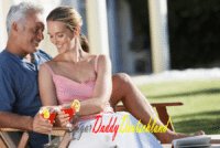 sugar baby lächelt glücklich, während sie mit ihrem sugar daddy etwas trinkt.