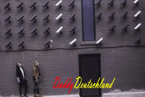 Mann und Frau schauen auf viele Überwachungskameras.