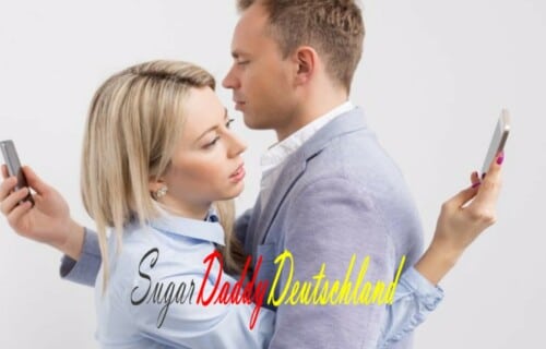 Hombre y mujer abrazados mientras miran sus móviles