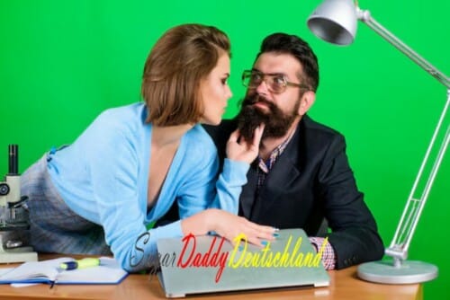 Eine Frau flirtet mit einem Mann, der am Tisch sitzt und lernt. Der Mann wirkt intelligent, fleißig und reif.